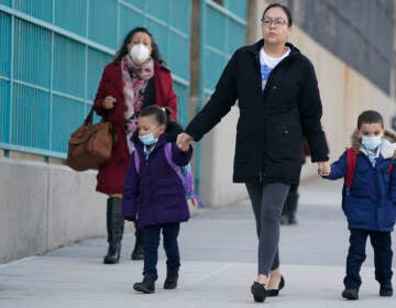 FILE - Children and their caregivers arrive for school in New York, Monday, March 7, 2022.  The Biden administration will extend for two weeks the nationwide mask requirement for public transit as it monitors an uptick in COVID-19 cases. The Centers for Disease Control and Prevention was set to extend the order, which was to expire on April 18, by two weeks to monitor for any observable increase in severe virus outcomes as cases rise in parts of the country.   (AP Photo/Seth Wenig, File)