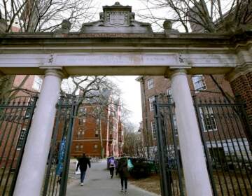 FILE - In this Dec. 13, 2018, file photo, a gate opens to the Harvard University campus in Cambridge, Mass. Harvard President Lawrence Bacow announced Tuesday, April 26, 2022 that the university is committing $100 million to study its ties to slavery and create a 
