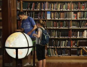 Visitors look at a globe in the map division at the main branch of the New York Public Library in New York. The library announced an effort this week to make commonly banned books available through their app. (Seth Wenig/AP)