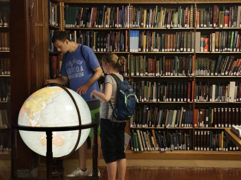 Visitors look at a globe in the map division at the main branch of the New York Public Library in New York. The library announced an effort this week to make commonly banned books available through their app. (Seth Wenig/AP)