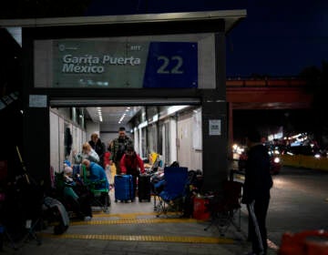 Ukrainian refugees wait in a bus stop near the border Monday, April 4, 2022, in Tijuana, Mexico.