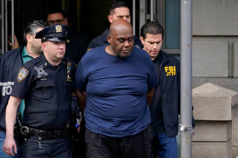 New York City Police and law enforcement officials lead subway shooting suspect Frank R. James, 62, center, away from a police station