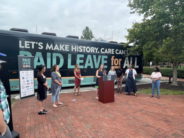 Delaware state Sen. Sarah McBride (at podium) and Dawn Huckelbridge of Paid Leave for All (in maroon dress) were staunch advocates of the measure. (Cris Barrish/WHYY)