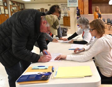 File photo: Caucus goers sign in on February 3, 2020 in Carpenter, Iowa. Iowa is the first contest in the 2020 presidential nominating process with the candidates then moving on to New Hampshire. (Steve Pope/Getty Images via NPR)