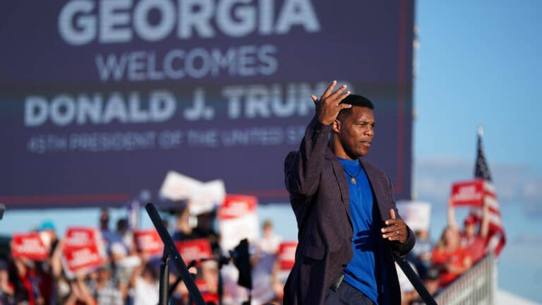 Republican Senate candidate Herschel Walker walks off the stage during a rally