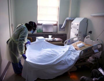 Tanetshia Brown changes bed linens for a COVID-19 patient