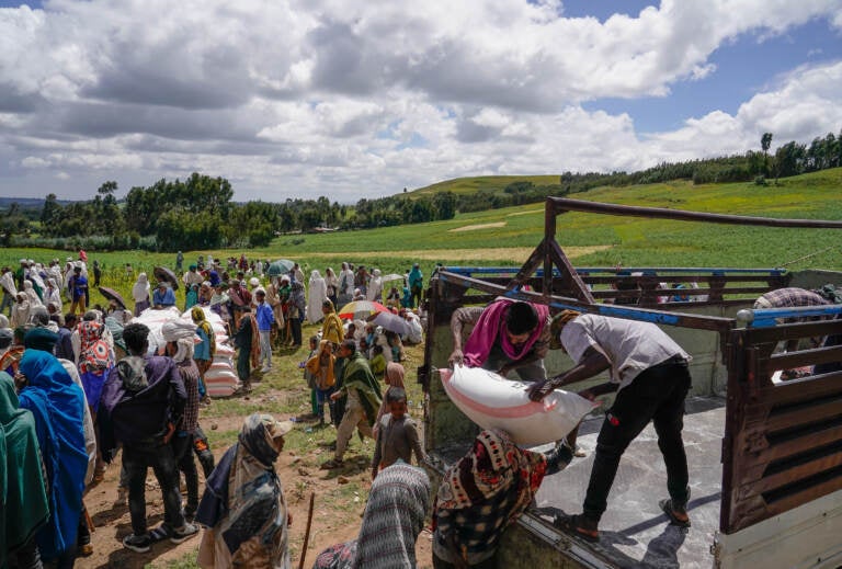 Volunteers unload food aid in Chena, Ethiopia, one of many parts of the world where conflict has fueled hunger. (Jemal Countess/Getty Images)