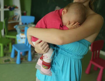 A baby sleeps in her mother's arms.