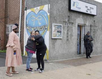 Penny Martin (left) and the Rev. Michelle Simmons, founder and executive director of Why Not Prosper, hug outside of a recovery home in Philadelphia.