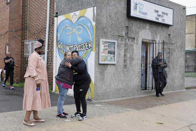 Penny Martin (left) and the Rev. Michelle Simmons, founder and executive director of Why Not Prosper, hug outside of a recovery home in Philadelphia.