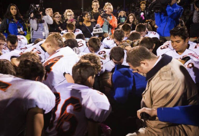 The parties included this image, of Coach Kennedy praying with a crowd after the homecoming game, in their joint appendix submitted to the Supreme Court
(Court Filings)