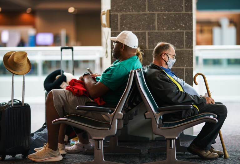 Travelers sit in a waiting area at Rhode Island T.F. Green International Airport