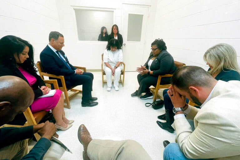 In this April 6, 2022 photo provided by Texas state Rep. Jeff Leach, Texas death row inmate Melissa Lucio, dressed in white, leads a group of seven Texas lawmakers in prayer in a room at the Mountain View Unit in Gatesville, Texas.