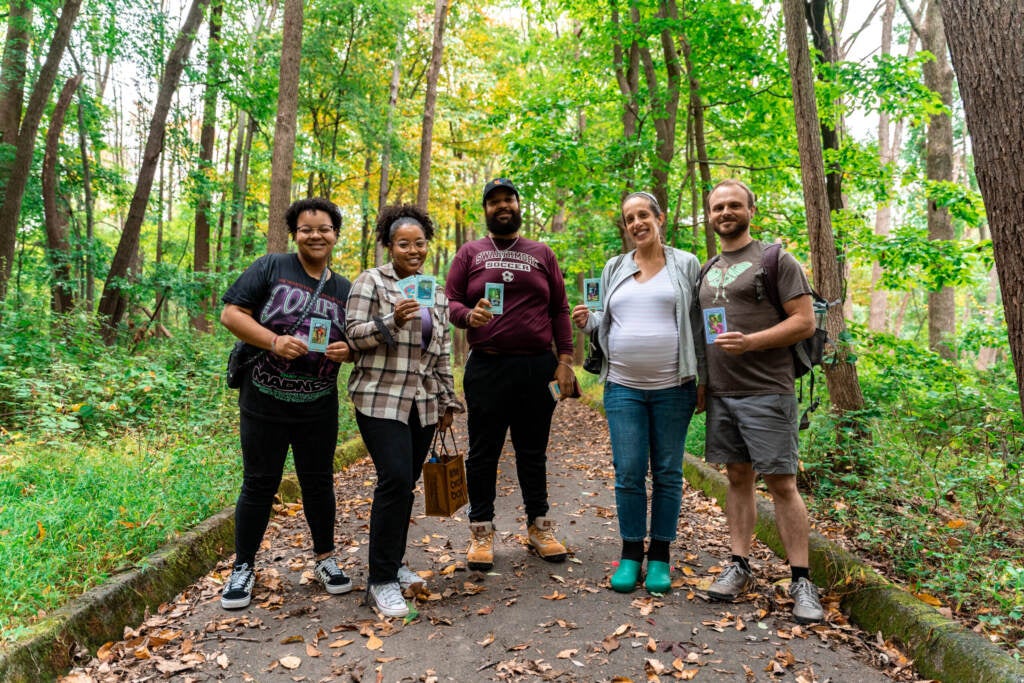 Hikers along the Schuylkill River trail hold up the Aquamarooned! card game.