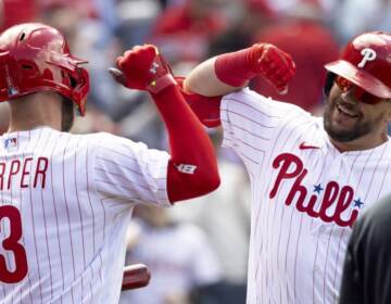 New outfielder Kyle Schwarber celebrates with Bryce Harper after hitting a home run in his first at-bat during the 2022 season opener against the Oakland Athletics on Friday.