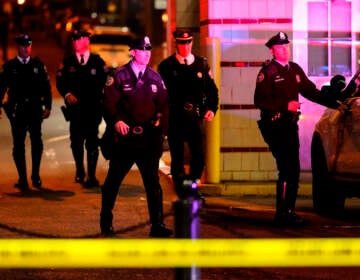 Police officers walk in the area of a shooting in Philadelphia