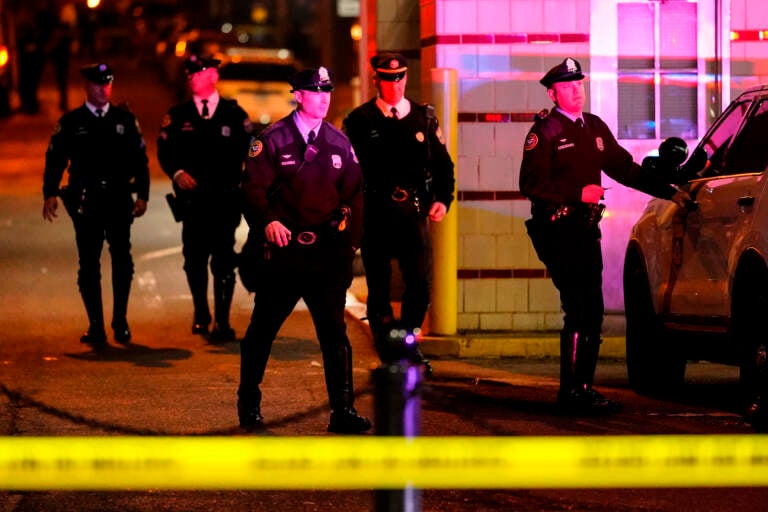 Police officers walk in the area of a shooting in Philadelphia