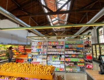 Fresh produce and stocked shelves of the grocery store, Riverwards Produce, are visible.