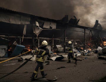 Firefighters work to extinguish a fire on a warehouse amid Russian bombardments in Kharkiv