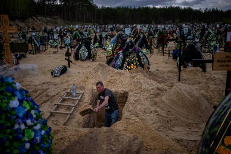 Alexander digs a grave at the cemetery of Irpin