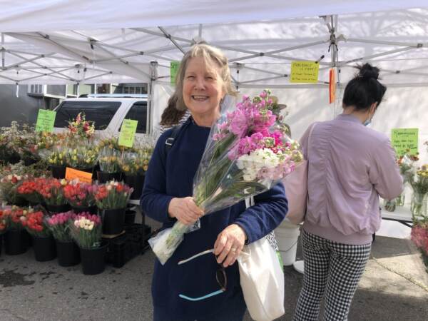 Julia Nesom just bought flowers from the Clark Park farmer’s market. She said she's keeping it low key this weekend and going to church to celebrate Easter on Sunday. (Emily Rizzo/WHYY News)