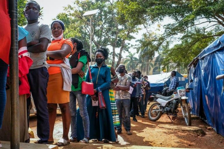 Ugandans queue to receive Pfizer COVID-19 vaccinations