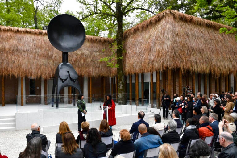 Simone Leigh, in red, stands in front of her 