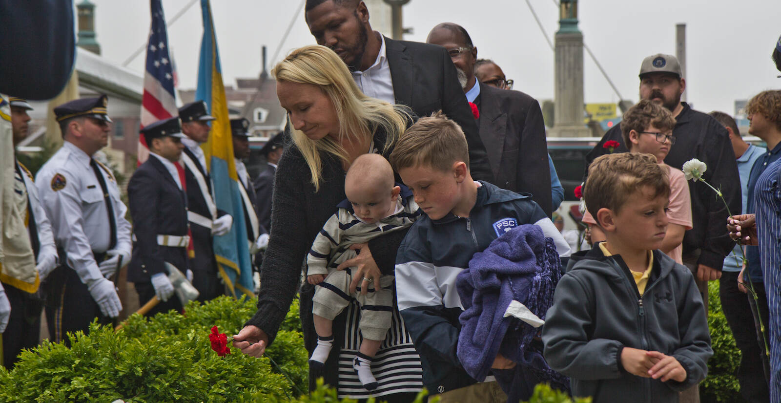 Family members of fallen police officers and firefighters placed flowers on their loved ones’ names at the the 2022 Living Flame Memorial Service. (Kimberly Paynter/WHYY)