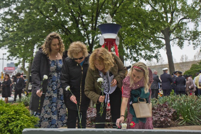 Family members who lost loved ones from any time are invited to the Living Flame Memorial Service to honor police officers and firefighters who lost their lives in the line of duty by placing flowers on their names. (Kimberly Paynter/WHYY)