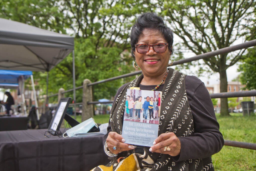 Deborah Kelly, a certified parent educator and retired teacher, holds her book The Turnaround at Clara Muhammad square on May 15, 2022.