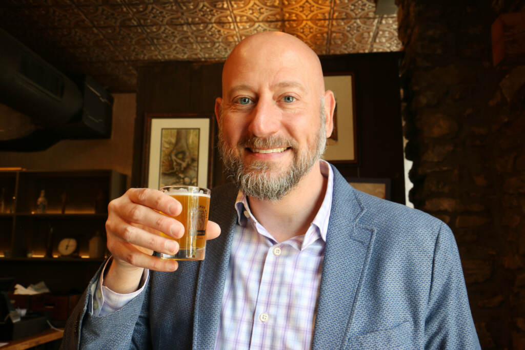 Chris Spangler, chief communications officer for Chestnut Hill College, tries a sample of Vale Pale Ale during the canning at Chestnut Hill Brewing Company.