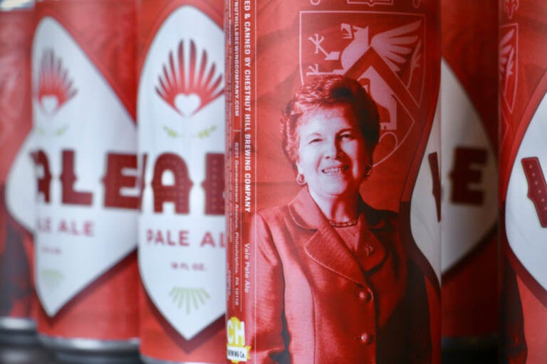 Image of red beer cans, emblazoned with the image of Sister Carol Jean Vale.