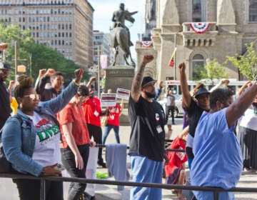 Attendees raise fists in remembrance of George Floyd on the two-year anniversary of Floyd’s murder