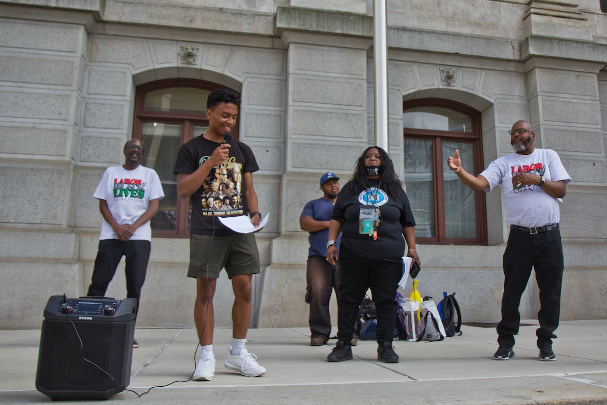 Joshua Sor, a student at Roman Catholic High School, and a member of the Philly Student Union, are cheered on by other union members as he demanded more funds be given to bettering communities over policing them, at a vigil for George Floyd outside City Hall in Philadelphia on May 25, 2022. (Kimberly Paynter/WHYY)