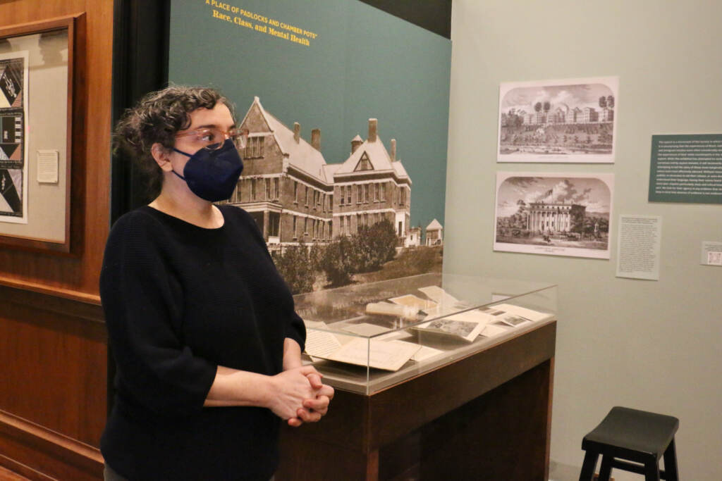 Library Company Curator Rachel D'Agostino stands in the middle of the "Hearing Voices" exhibition.