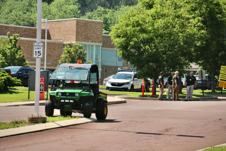Security guards stand outside the entrance to Pennridge High School in Perkasie, where students were holding a memorial for children killed in the Uvalde school shooting. Members of the press were not allowed to attend the event. (Emma Lee/WHYY)