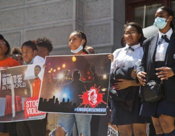 Students stand with signs, calling for an end to gun violence in Philly.