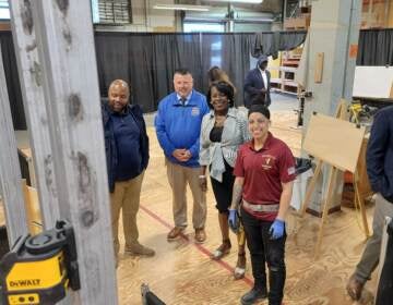 Apprentice Priscilla Torres (center, in red) stands with (left to right) Councilmember Cherelle Parker, Carpenters Union Head William Sproule and Ryan Boyer, who runs the Building Trades Council. (Tom MacDonald/WHYY)