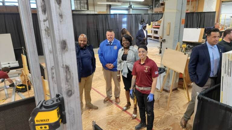 Apprentice Priscilla Torres (center, in red) stands with (left to right) Councilmember Cherelle Parker, Carpenters Union Head William Sproule and Ryan Boyer, who runs the Building Trades Council. (Tom MacDonald/WHYY)