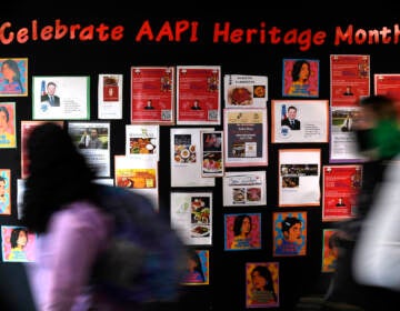 Students walk past a display for Asian Pacific American Heritage Month