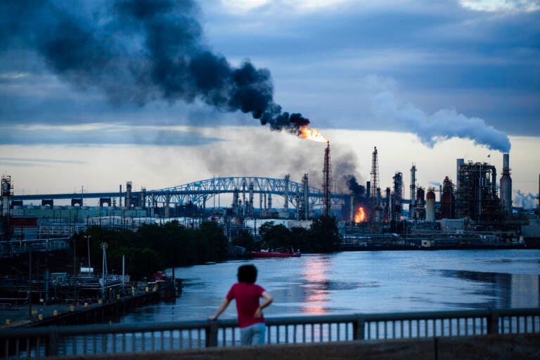 This photo from June 21, 2019 shows flames and smoke emerging from the Philadelphia Energy Solutions Refining Complex in Philadelphia. The blaze and a series of explosions shook homes and caused extensive damage at the refinery, the largest on the East Coast. The company shuttered the 150-year-old site and laid off workers. (AP Photo/Matt Rourke, File)