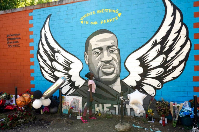 Nala Williams, 8, looks up at a mural honoring George Floyd in the Third Ward, Sunday, June 7, 2020, in Houston. (AP Photo/David J. Phillip