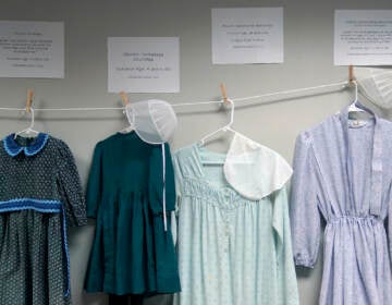 Dresses donated by sexual assault survivors from Amish and other plain-dressing religious groups hang on a clothesline beneath a description of each survivors' age and church affiliation, on Friday, April 29, 2022, in Leola, Pa. (AP Photo/Jessie Wardarski)