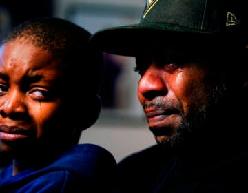 Wayne Jones, holds his son Donell, while speaking during an interview with The Associated Press about his mother Celestine Chaney, who was killed in Saturday's shooting at a supermarket, in Buffalo, N.Y., Monday, May 16, 2022. (AP Photo/Matt Rourke)