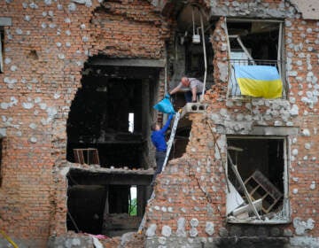 Residents take out their belongings from their house ruined by the Russian shelling in Irpin close to Kyiv, Ukraine, Saturday, May 21, 2022. (AP Photo/Efrem Lukatsky)