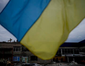 Men work at repairing a building damaged by shelling in Makariv, on the outskirts of Kyiv, Ukraine, Friday, May 27, 2022. (AP Photo/Natacha Pisarenko)