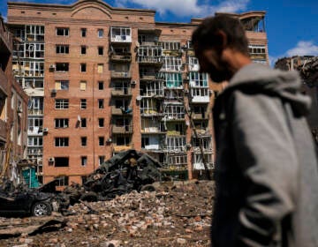 FILE - A man walks next to heavily damaged buildings and destroyed cars following Russian attacks in Bakhmut, Donetsk region, eastern Ukraine, Tuesday, May 24, 2022. The region, along with neighboring Luhansk, is part of the Donbas, where Russian forces have focused their offensive. (AP Photo/Francisco Seco, File)