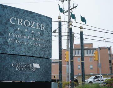 A sign for Crozer Health is visible in the foreground, with buildings in the background.