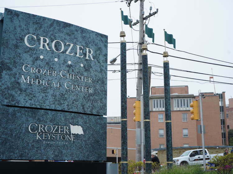 A sign for Crozer Health is visible in the foreground, with buildings in the background.
