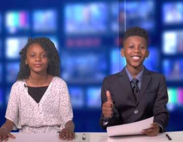 Two children behind a news desk thank the audience for watching the film.